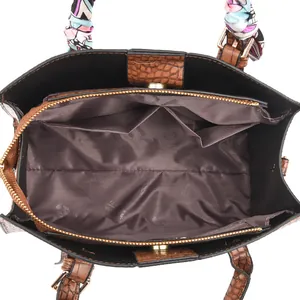 Top view detail of embossed tote bag interior with multiple compartments and silk scarf