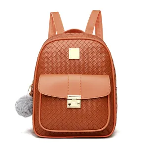 Close-up of brown faux leather backpack with woven texture, gold clasp and grey fur ball