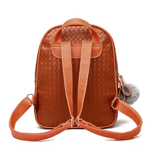 Close-up of brown faux leather backpack featuring intricate woven texture and metal hardware
