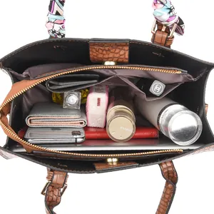 Brown crocodile embossed leather tote bag featuring a spacious interior and silk scarf detail