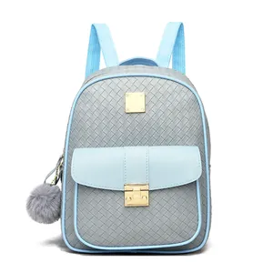 Close-up of the grey woven texture with a gold metal lock and plush ball charm