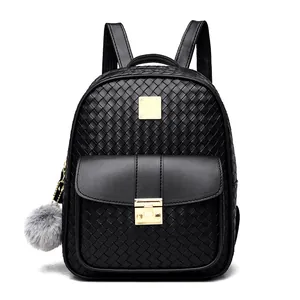 Close-up of black PU backpack with woven texture, golden metal lock, and grey fur ball charm