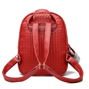 Detail of red woven leather backpack showing straps and gray plush ball keychain