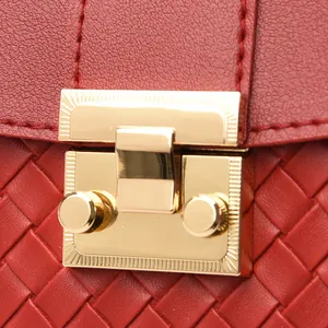Detailed macro view of woven red leather backpack with golden metal buckle and stitching