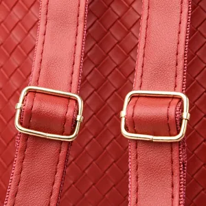 Detailed close-up of red woven PU leather backpack straps with gold adjustment buckles