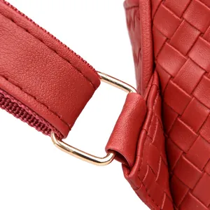 Detail of red woven PU leather backpack featuring a luxury gold metal square buckle clasp