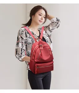 Détail du sac à dos en nylon rouge imperméable avec fermeture éclair dorée et poches