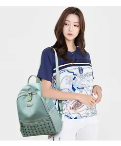 Fashionable mint green nylon backpack with rivet details shown on model with sea theme t-shirt