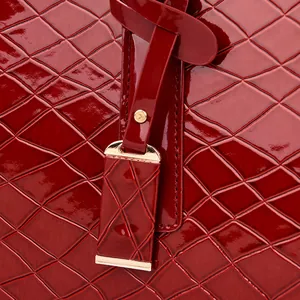Detail der roten Stepp-Kunstleder-Textur mit elegantem Goldmetall-Anhänger und Nieten