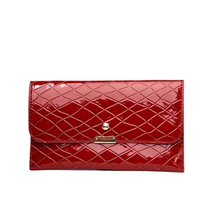 Detailansicht der roten Lackleder-Clutch mit Krokoprägung und goldenem Verschluss
