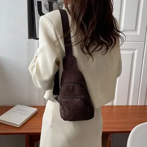 Detail of coffee brown corduroy chest bag texture with adjustable nylon shoulder strap