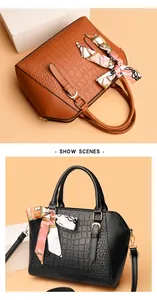 Detailed view of crocodile embossed leather texture on brown and black tote bags with scarves