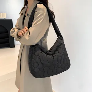 Dettaglio della borsa trapuntata nera con motivo floreale 3D e texture in nylon