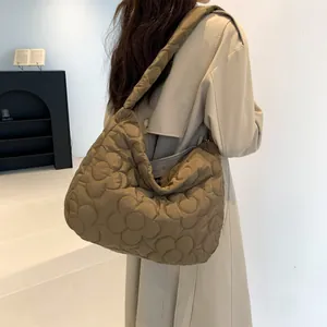 Vista laterale della grande borsa hobo trapuntata marrone oliva con motivo floreale