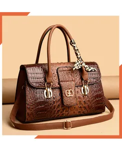 Macro detail of brown crocodile texture leather bag with silk scarf and gold hardware