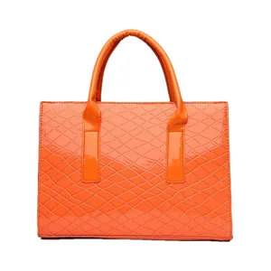 Orangefarbene Handtasche mit Krokodilmuster und Glanzfinish im 3er-Set auf weißem Grund