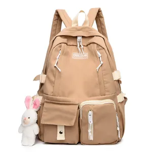Large khaki nylon backpack for students featuring contrast straps and a plush bunny pendant
