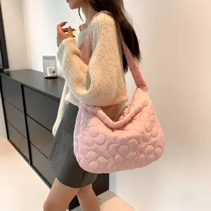 Dettaglio macro della borsa tote trapuntata rosa con motivo floreale e morbido nylon