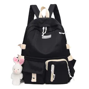 Black high-density nylon backpack for students featuring cream straps and a rabbit charm