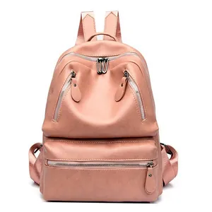 Detailed close-up of pink PU leather backpack showing silver zippers and top handle