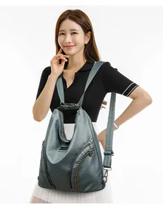 Detail showing grey-blue PU leather backpack with silver studs and metal zippers