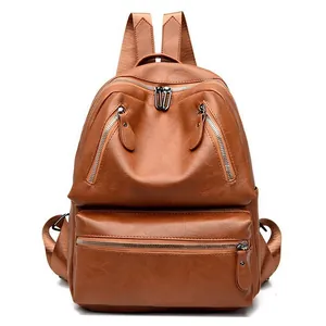 Detail view of brown PU leather backpack with double front zippers and fabric straps