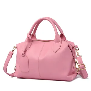 Dettaglio borsa Boston rosa con trama litchi, finiture dorate e tracolla