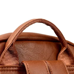 Detail shot of brown PU leather backpack handle with litchi texture and neat stitching
