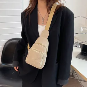 Detail of beige corduroy crossbody bag showing soft ribbed texture and silver zippers