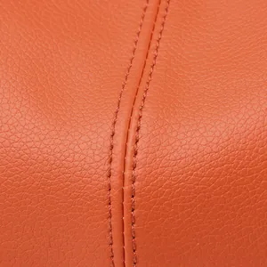 Dettaglio ravvicinato di borsa arancione in pelle con venature e cuciture doppie rifinite