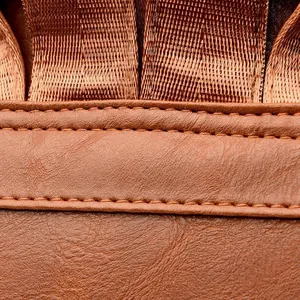 Detail of dark brown leather texture with durable double stitching and nylon webbing strap