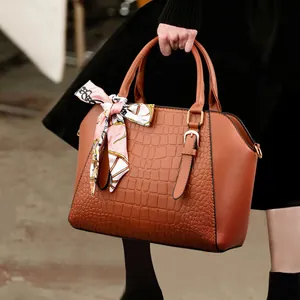Brown crocodile embossed tote bag with elegant floral scarf detail and golden hardware