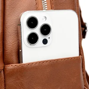 Detail of a brown PU leather backpack side pocket showing capacity for a smartphone