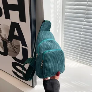 Detail of teal corduroy chest bag featuring vertical texture and adjustable strap