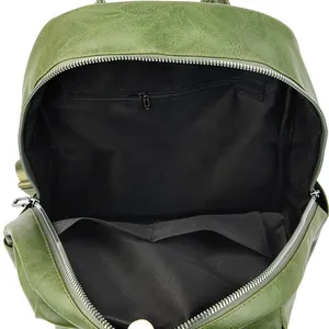 Detailed view of green PU leather backpack interior with black lining and zip pocket