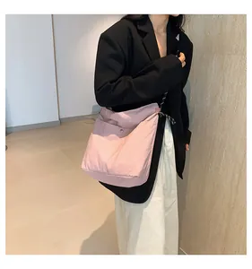 Pink nylon crossbody bag detail with black and white drawstring and metal snap button