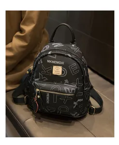 Detail of black pebbled leather mini backpack with letter prints and golden metal plaque