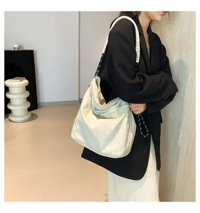 Detail of off-white nylon tote bag showing its unique black and white rope shoulder strap
