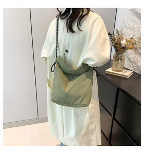 Detail of light green nylon crossbody bag showing soft texture and knotted strap detail