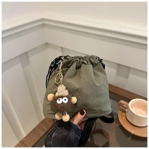 Borsa a secchiello verde scuro con coulisse e simpatico ciondolo mostro di peluche
