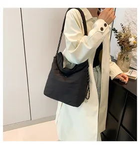 Detail of black nylon hobo bag with thick braided rope shoulder strap for a minimalist look