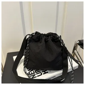 Borsa a secchiello minimalista in nylon nero plissettato con cordoncino e tracolla trendy