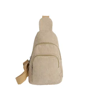 Close-up of beige corduroy sling bag with dual zipper compartments and adjustable strap