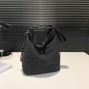Minimalist black nylon tote bag featuring a thick black and white braided rope shoulder strap