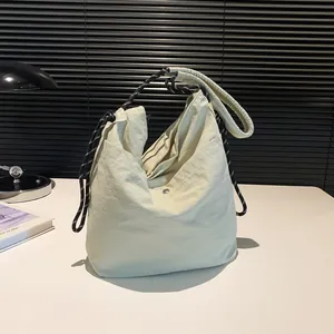 Minimalist cream nylon tote bag with unique black and white checkered woven rope strap