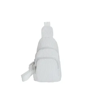 Detail view of white corduroy waist bag showing vertical texture and silver zippers