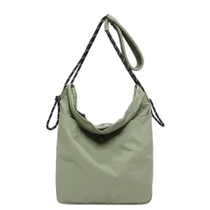 Minimalist light green nylon crossbody bag with stylish black and white woven strap