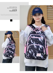 Detail of a camo youth backpack with pink zippers and multi-layer storage compartments