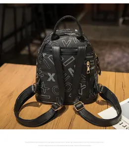 Detailed back view of a mini black backpack with white letters and a gold zipper pocket