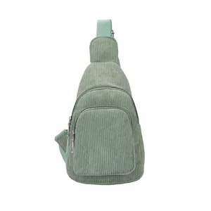 Detail of light green corduroy crossbody bag with multi-layer metal zippers and adjustable strap